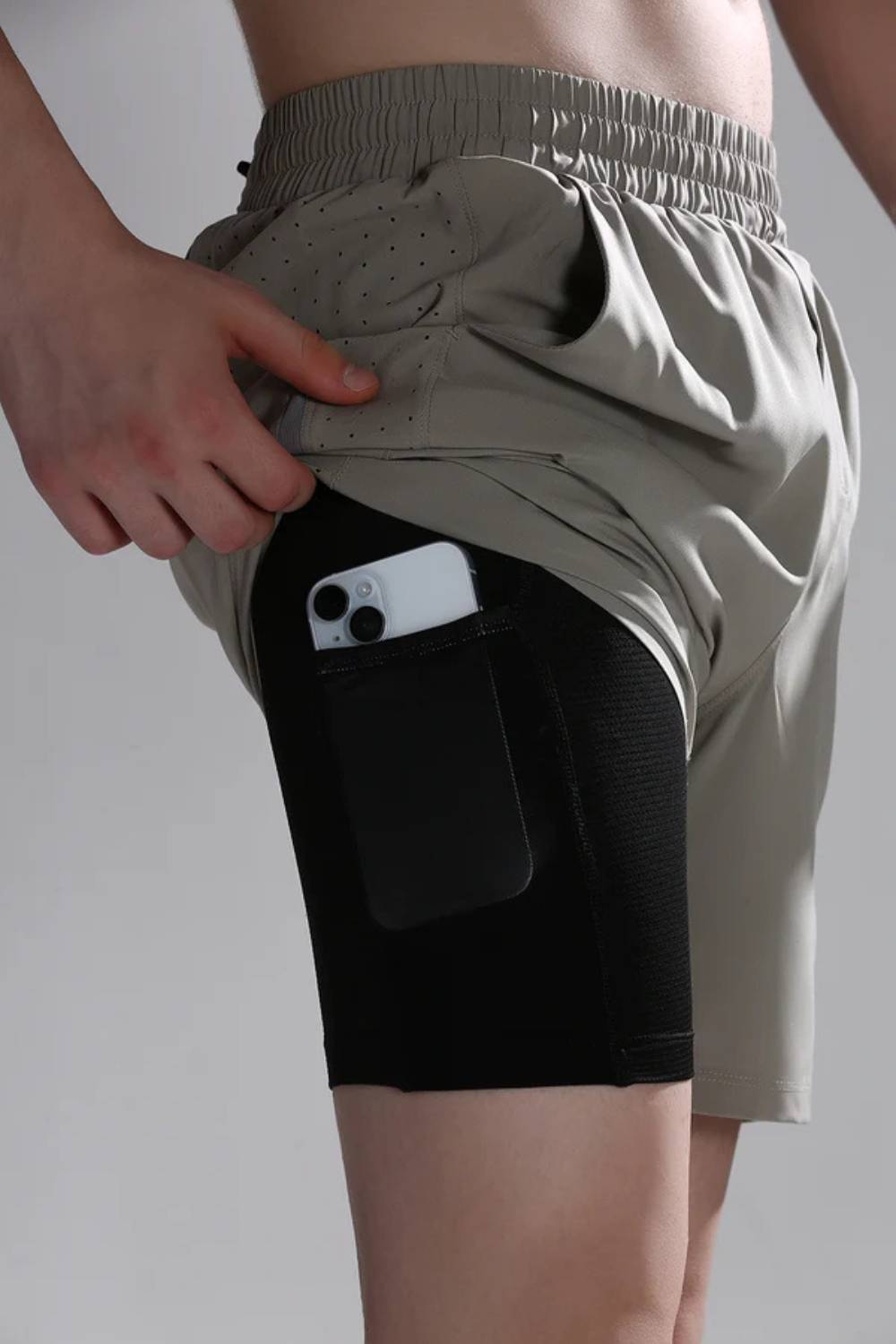 Inner thigh pocket on compression lining of running shorts  holding phone #Color_Tech Beige